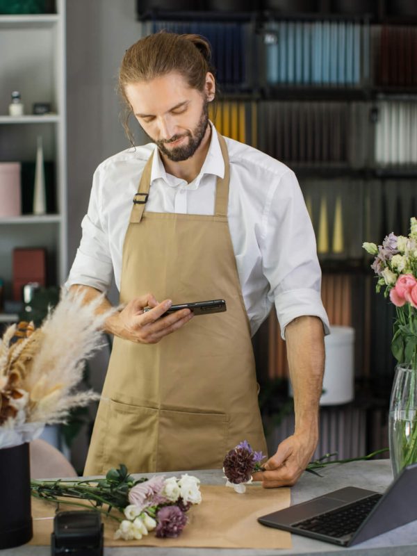 florists-making-bouquet-of-flowers-on-counter-and-taking-photo-on-smartphone-for-social-media-.jpg